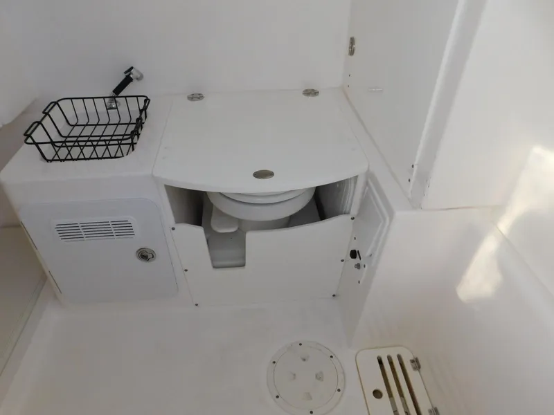 Slide: The Image of 2016 Everglades 355 Center Console boat bathroom with toilet and storage compartments. - 33