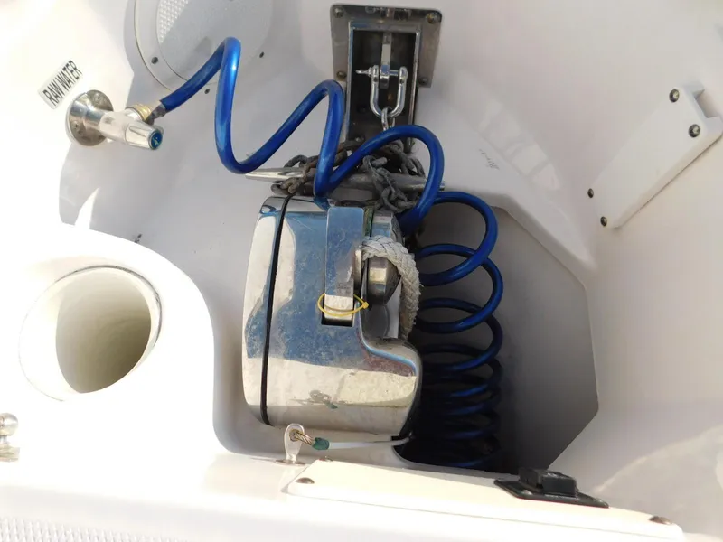 Slide: The Image of 2016 Everglades 355 Center Console anchor storage with blue coiled hose and metal fittings. - 44