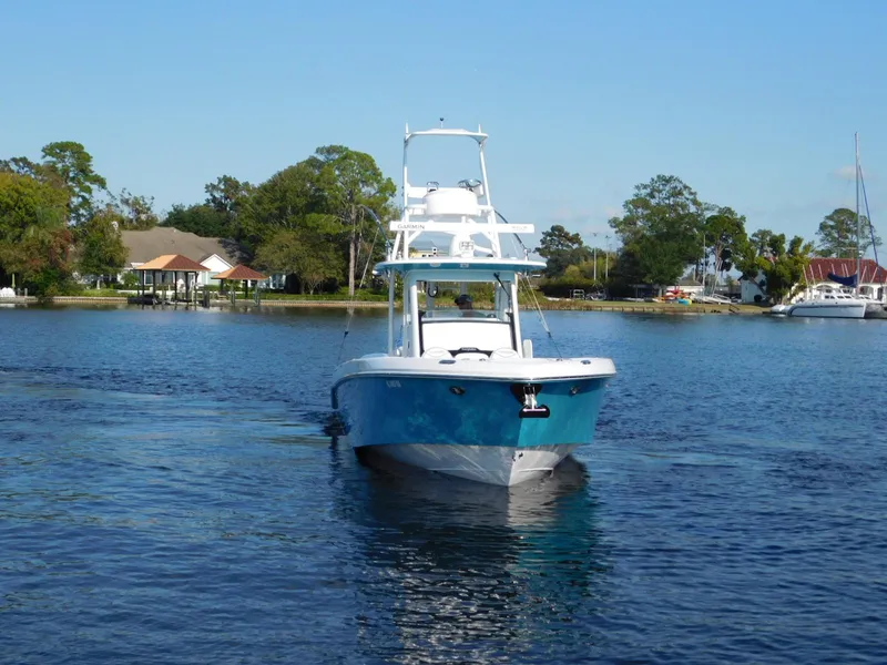 Slide: The Image of 2016 Everglades 355 Center Console boat on a serene lake with trees and houses. - 5