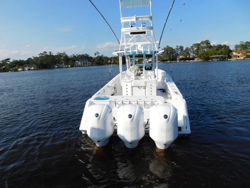 Slide: The Image of 2016 Everglades 355 Center Console boat with four outboard engines on a calm lake. - 8