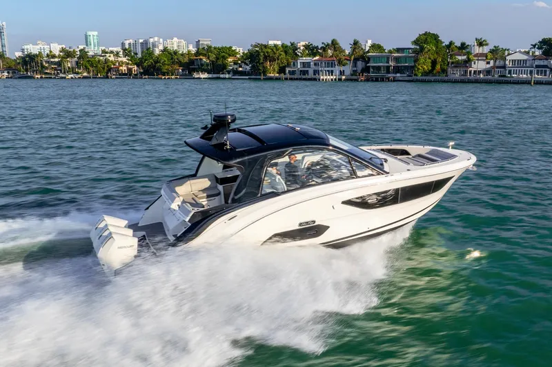 Slide: The Image of 2023 Sea Ray Sundancer 370 OB cruising on a scenic waterfront. - 2