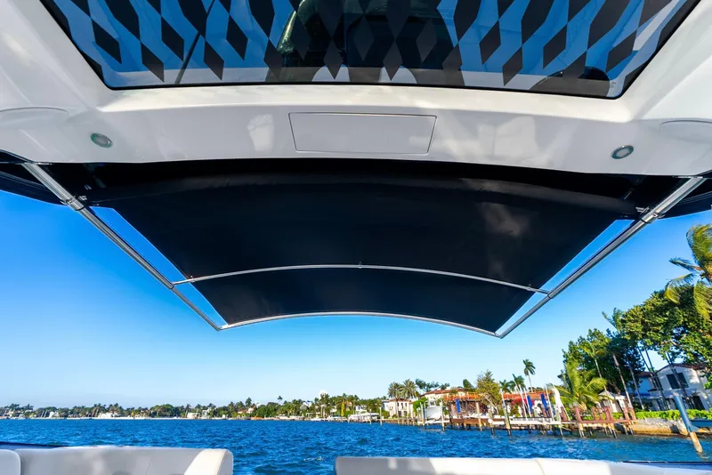Slide: The Image of 2023 Sea Ray Sundancer 370 OB boat canopy with scenic waterfront view. - 20