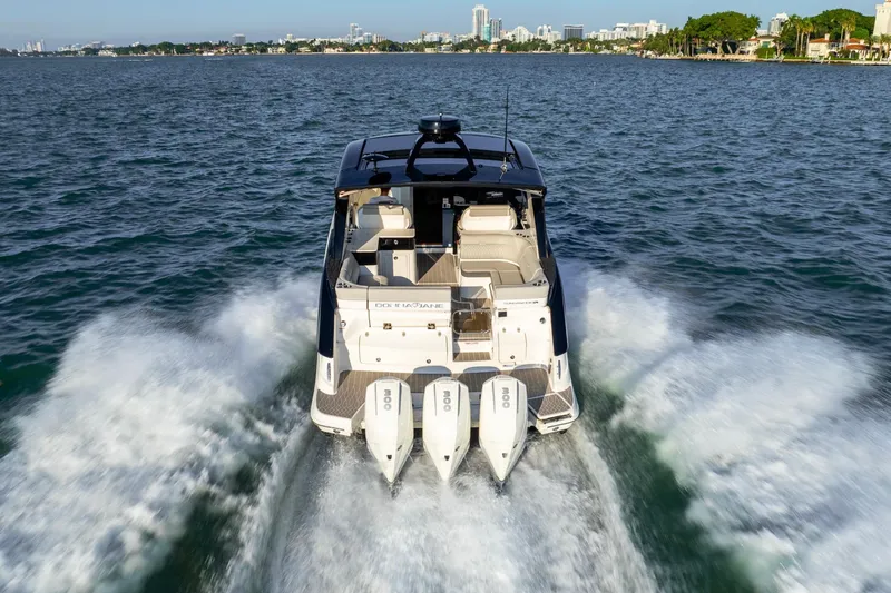 Slide: The Image of 2023 Sea Ray Sundancer 370 OB cruising on open water, rear view. - 6