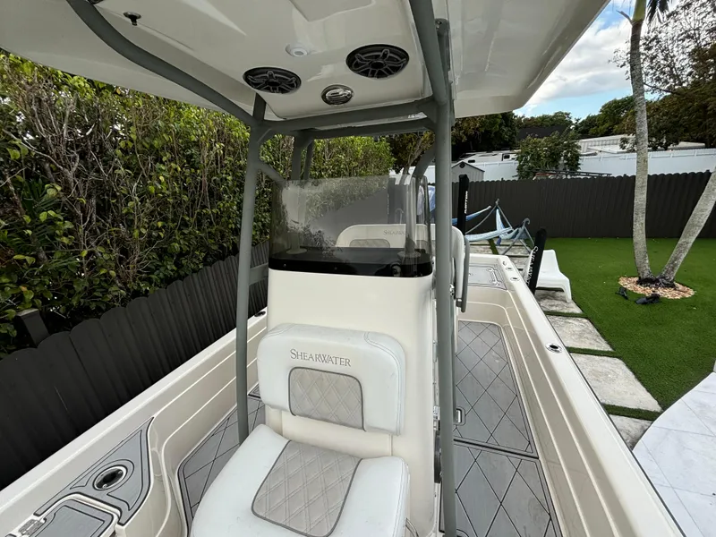 Slide: The Image of 2014 ShearWater 25LTZ boat interior with seating and console, outdoor setting. - 13