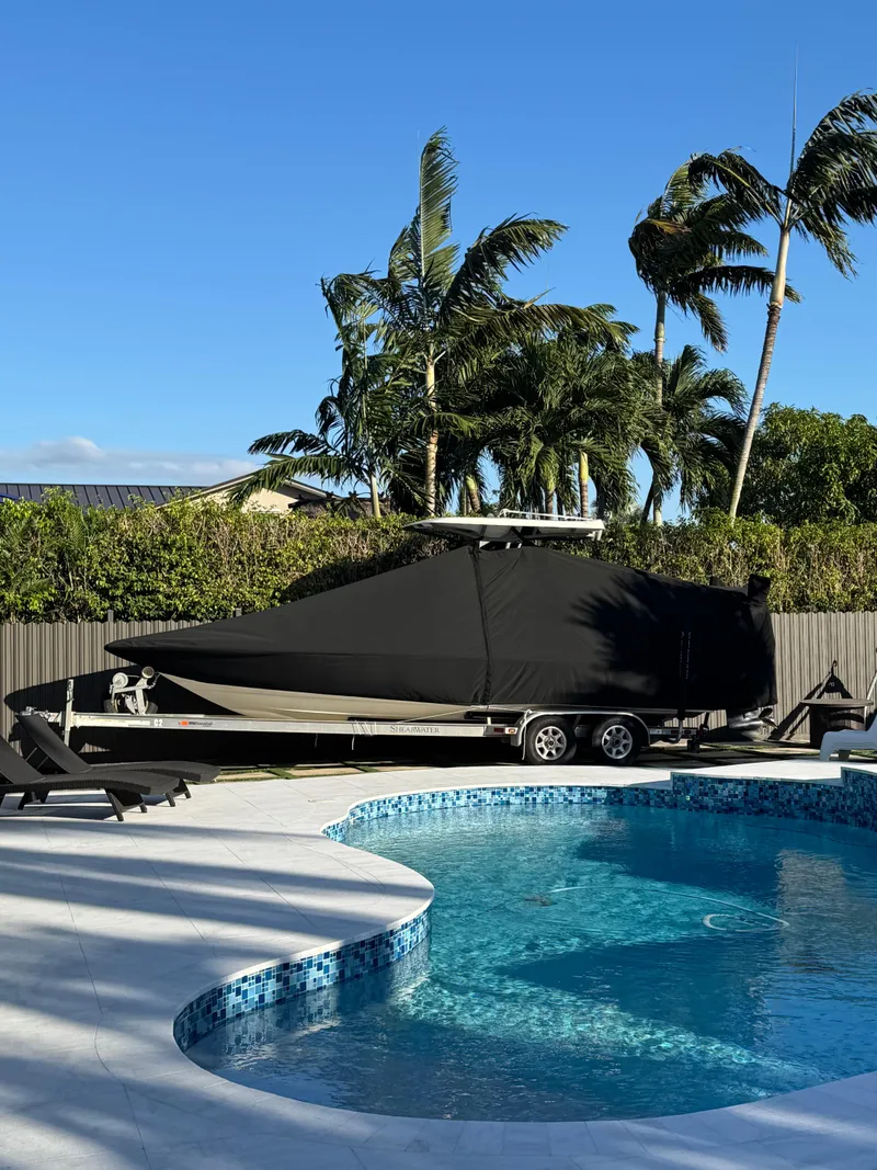 Slide: The Image of 2014 ShearWater 25LTZ boat covered near a pool with palm trees. - 14