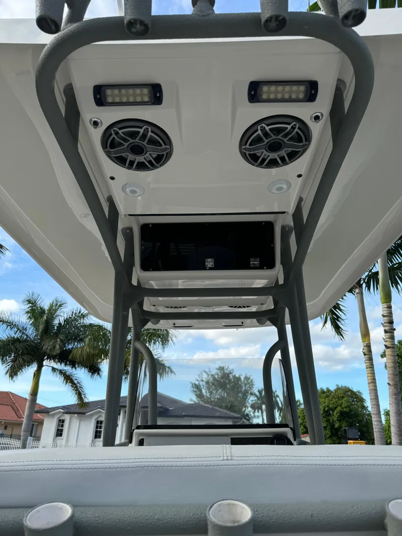Slide: The Image of 2014 ShearWater 25LTZ boat T-top with speakers and lights, palm trees in background. - 15