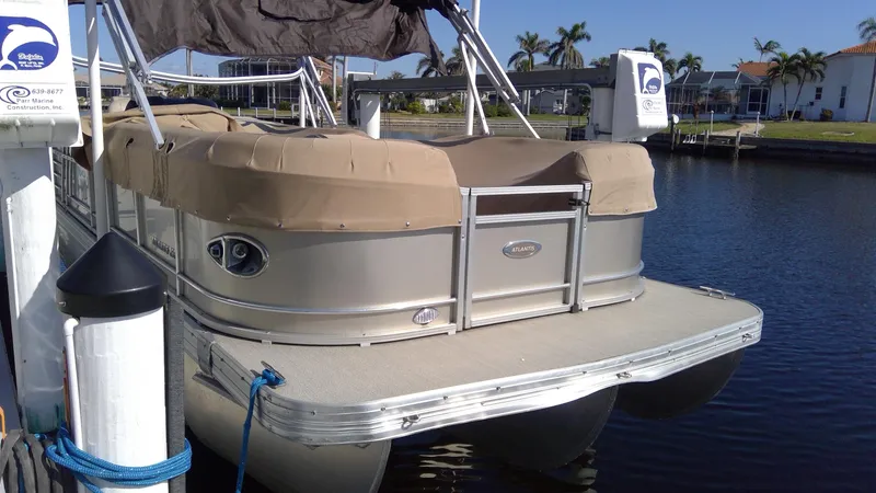 Slide: The Image of 2020 Landau Atlantis 250 Cruise pontoon boat docked by waterfront homes. - 12