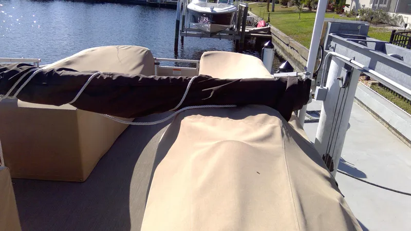 Slide: The Image of 2020 Landau Atlantis 250 Cruise boat with protective covers docked by the water. - 14