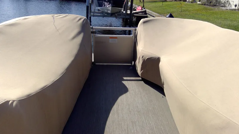 Slide: The Image of 2020 Landau Atlantis 250 Cruise boat with covered seating, docked by a calm waterway. - 17