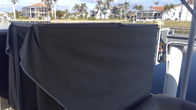 Slide: The Image of 2020 Landau Atlantis 250 Cruise boat with cover, near waterfront homes and palm trees. - 28