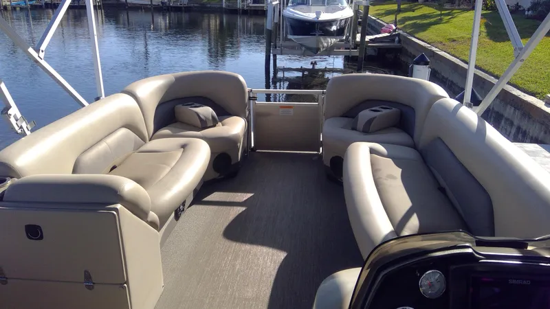Slide: The Image of 2020 Landau Atlantis 250 Cruise pontoon boat interior with plush seating by the water. - 36