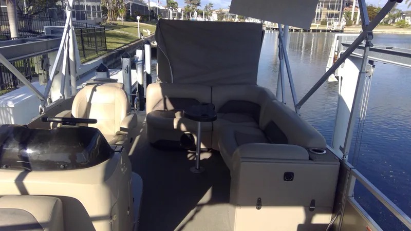 Slide: The Image of 2020 Landau Atlantis 250 Cruise pontoon boat interior with seating and table on a sunny day. - 40