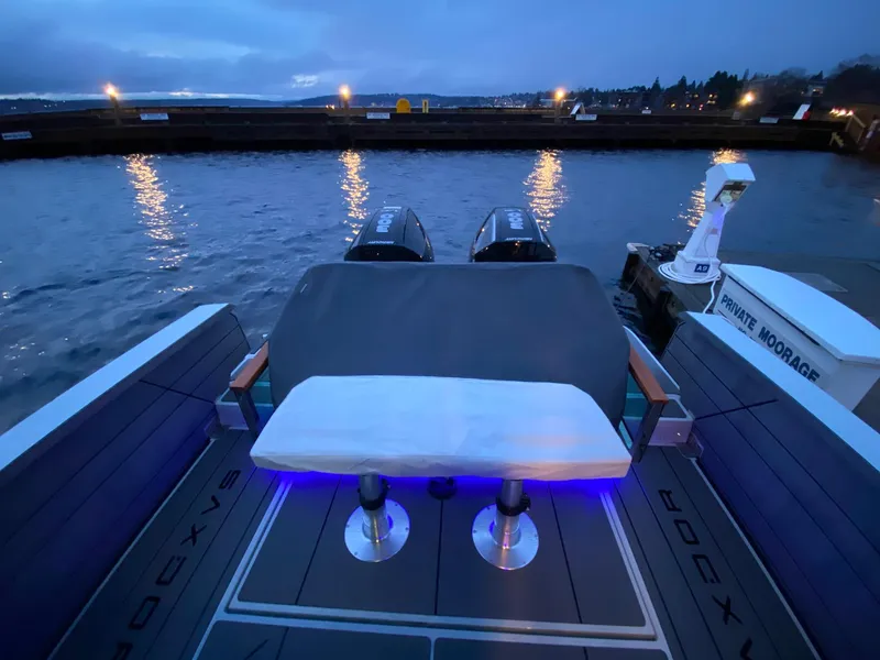 Slide: The Image of Saxdor 320 GTC 2025 boat at dusk, docked with illuminated seating area. - 13