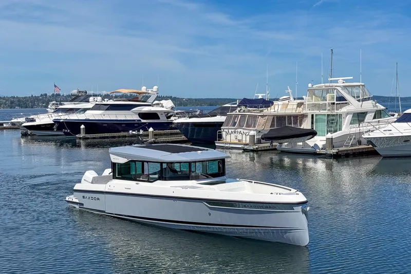 Slide: The Image of 2025 Saxdor 320 GTC boat cruising in a marina with yachts in the background. - 3