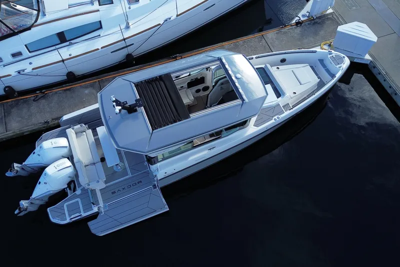 Slide: The Image of 2025 Saxdor 320 GTC boat docked, aerial view, showcasing sleek design and twin engines. - 5