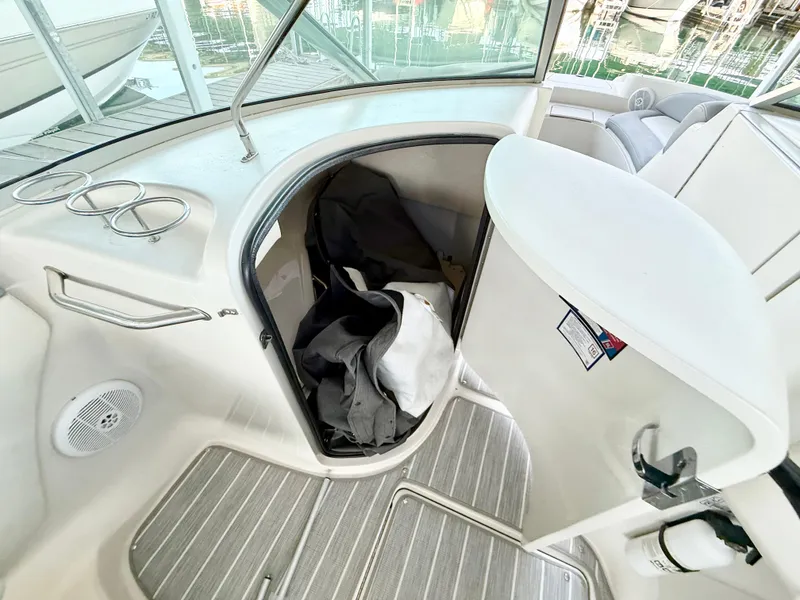 Slide: The Image of 2003 Sea Ray 270 Sundeck interior with storage compartment and seating area. - 10