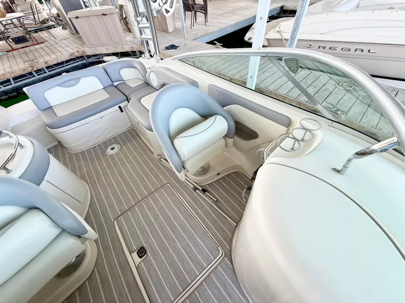 Slide: The Image of 2003 Sea Ray 270 Sundeck interior with seating and helm, docked at marina. - 12