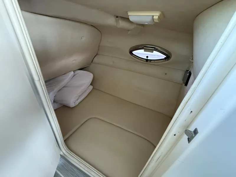 Slide: The Image of 2003 Sea Ray 270 Sundeck cabin interior with porthole and cushions. - 14