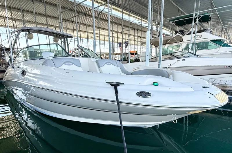 Slide: The Image of 2003 Sea Ray 270 Sundeck boat docked in a marina under a covered structure. - 22
