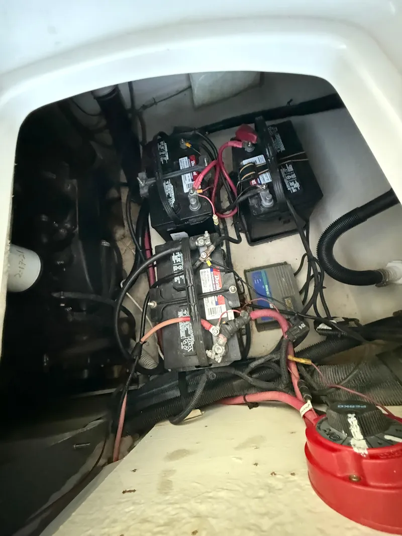Slide: The Image of 2003 Sea Ray 270 Sundeck battery compartment with multiple batteries and wiring. - 23