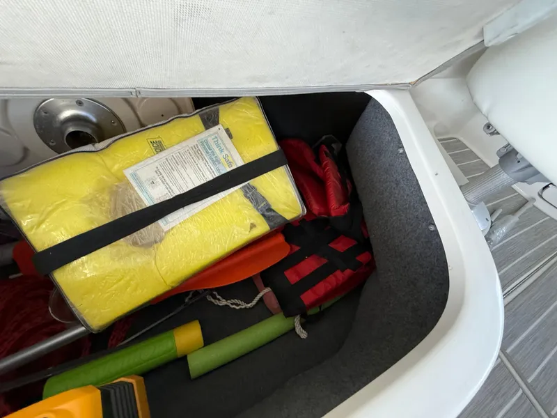 Slide: The Image of Storage compartment in a 2003 Sea Ray 270 Sundeck with life jackets and safety gear. - 24