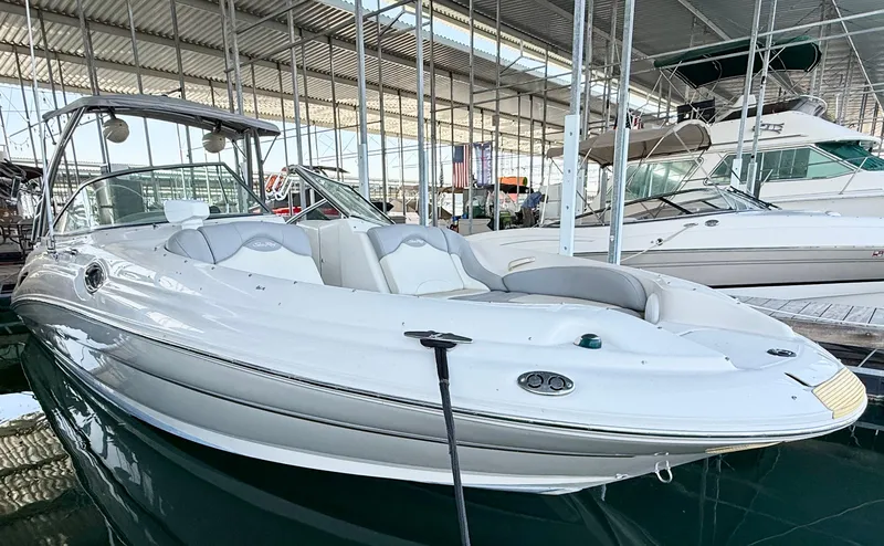 Slide: The Image of 2003 Sea Ray 270 Sundeck boat docked in a marina under a covered structure. - 6
