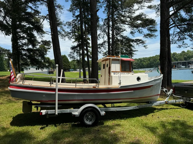 The Image of 1990 Ranger Tugs R21 Classic boat on trailer by lakeside, surrounded by trees. - 0