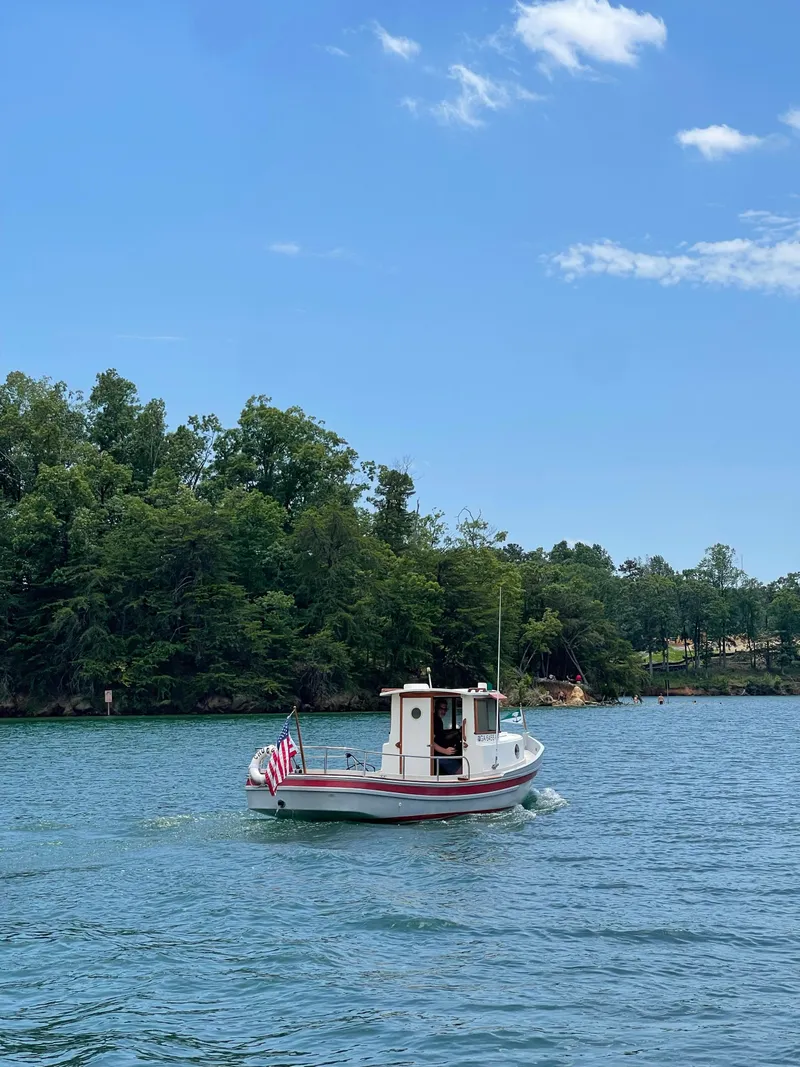 Slide: The Image of 1990 Ranger Tugs R21 Classic boat on a scenic lake with trees and blue sky. - 13