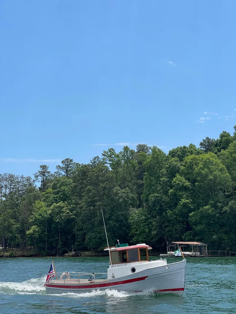 Slide: The Image of 1990 Ranger Tugs R21 Classic boat cruising on a lake with lush green trees. - 16