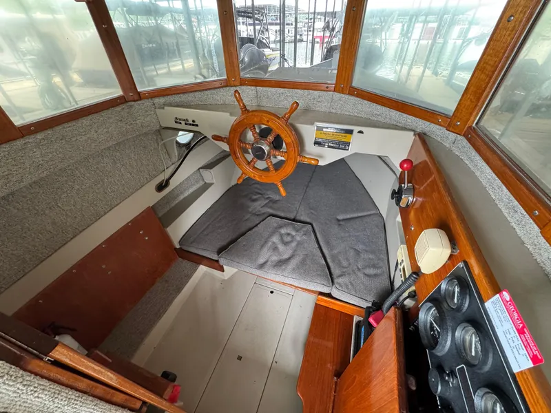 Slide: The Image of 1990 Ranger Tugs R21 Classic boat interior with wooden steering wheel and control panel. - 17