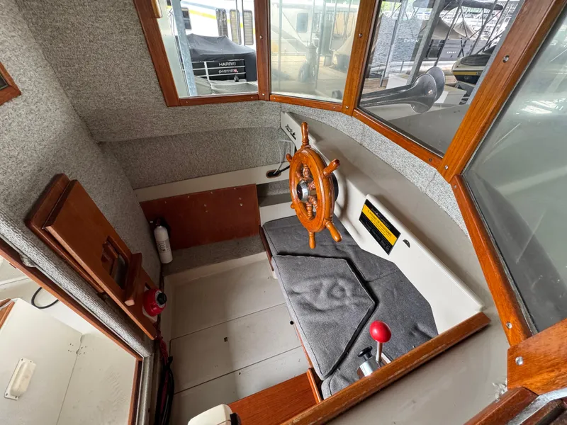 Slide: The Image of 1990 Ranger Tugs R21 Classic boat interior with wooden steering wheel and control panel. - 19