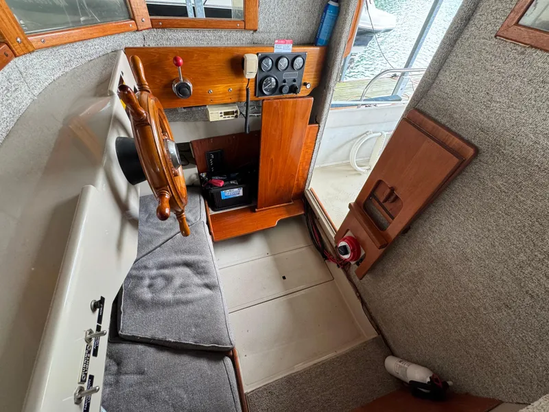 Slide: The Image of Interior of a 1990 Ranger Tugs R21 Classic boat with wooden steering wheel. - 21