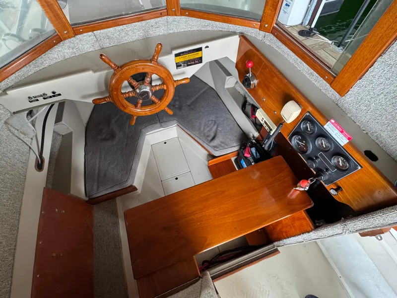 Slide: The Image of 1990 Ranger Tugs R21 Classic interior with wooden helm and seating area. - 23