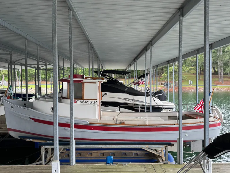 Slide: The Image of 1990 Ranger Tugs R21 Classic docked under a covered marina. - 25