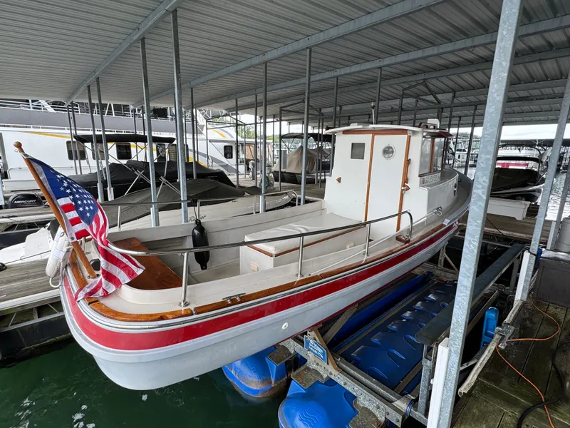 Slide: The Image of 1990 Ranger Tugs R21 Classic boat docked under a covered marina with American flag. - 28