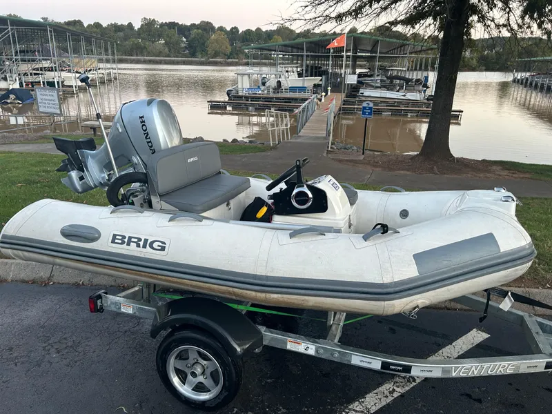 Slide: The Image of 2022 Brig Falcon Tender 300 inflatable boat on trailer by a lakeside dock. - 18
