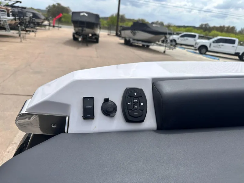 Slide: The Image of 2024 Aviara AV28 boat control panel with buttons, docked boats in the background. - 11