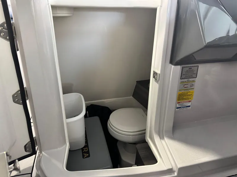 Slide: The Image of 2024 Aviara AV28 boat interior bathroom with toilet and storage space. - 22