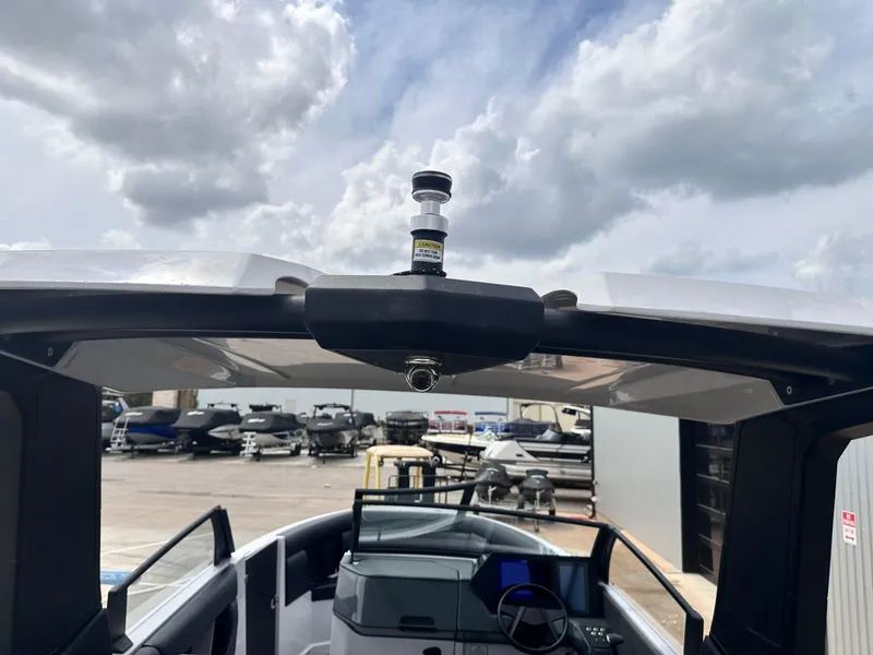 Slide: The Image of 2024 Aviara AV28 boat interior with modern dashboard and open roof, under a cloudy sky. - 30