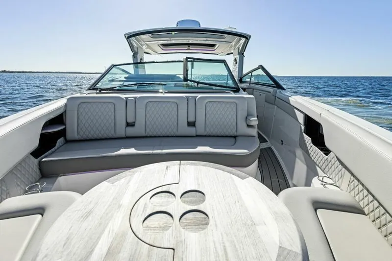 Slide: The Image of 2023 Sea Ray SLX 400 OB luxury boat interior with seating and table on open water. - 25
