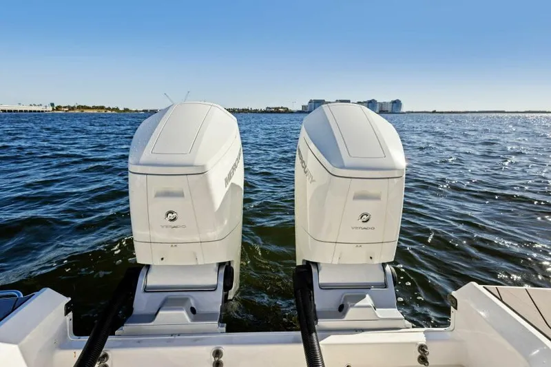 Slide: The Image of 2023 Sea Ray SLX 400 OB boat with twin outboard engines on open water. - 6