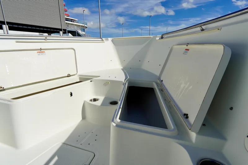 Slide: The Image of 2009 Sailfish 2860 CC boat interior with open storage compartments under a clear blue sky. - 14