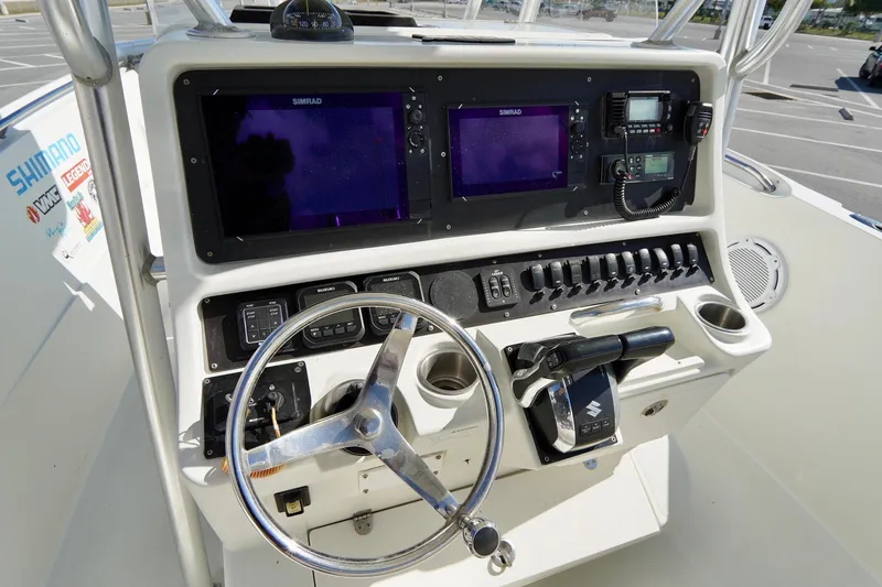 Slide: The Image of 2009 Sailfish 2860 CC boat dashboard with dual Simrad displays and steering wheel. - 19