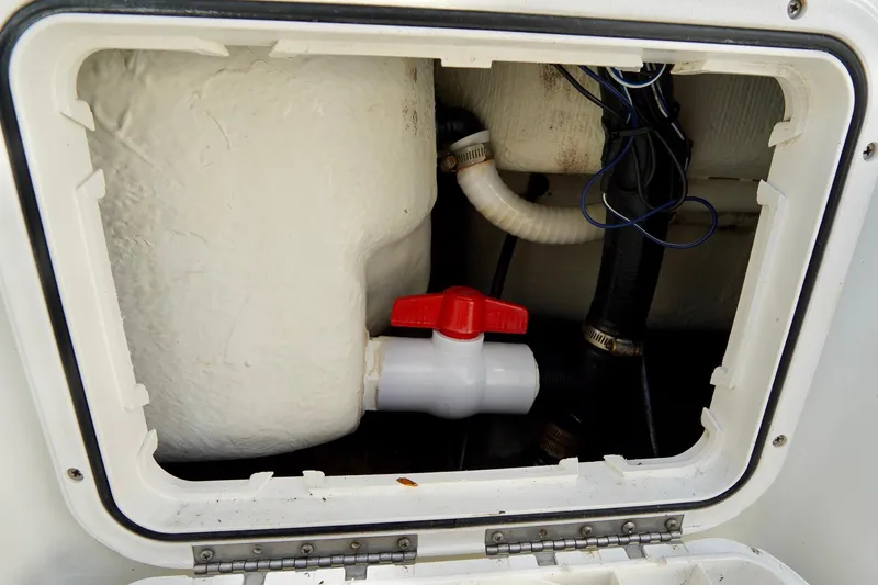 Slide: The Image of 2009 Sailfish 2860 CC boat plumbing system with red valve and hoses. - 32