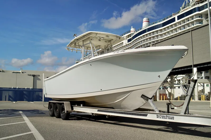 Slide: The Image of 2009 Sailfish 2860 CC boat on trailer, docked near a cruise ship. - 4