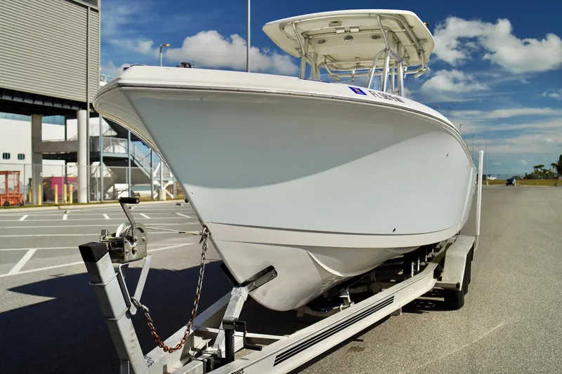 Slide: The Image of 2009 Sailfish 2860 CC boat on trailer, parked outdoors under blue sky. - 6