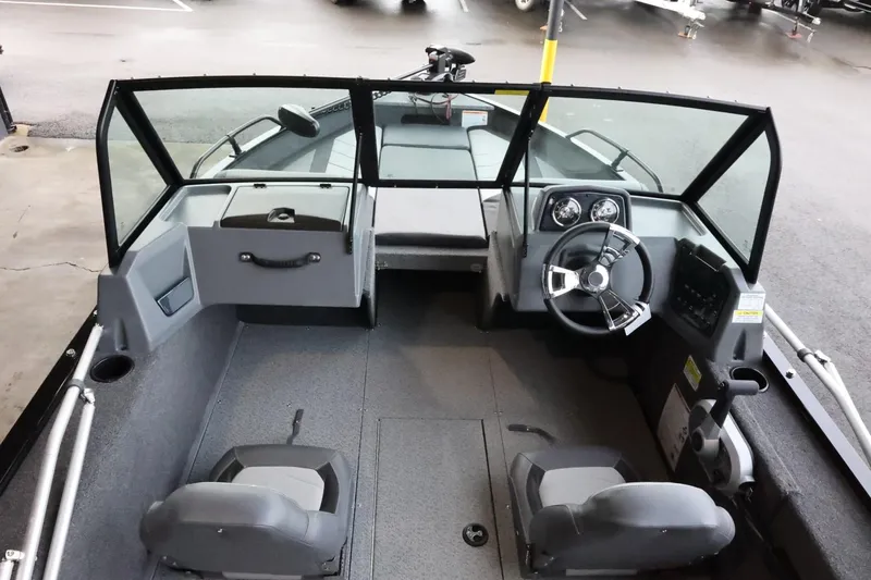 Slide: The Image of 2025 Lowe Fish & Ski FS 1625 boat interior with steering wheel and seating. - 10