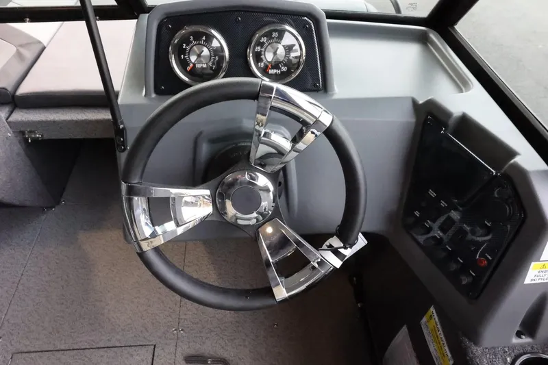 Slide: The Image of 2025 Lowe Fish & Ski FS 1625 boat dashboard with modern steering wheel and gauges. - 13