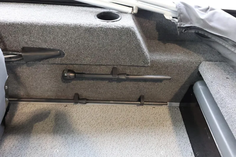 Slide: The Image of Interior of 2025 Lowe Fish & Ski FS 1625 boat, featuring storage compartment and rod holder. - 22