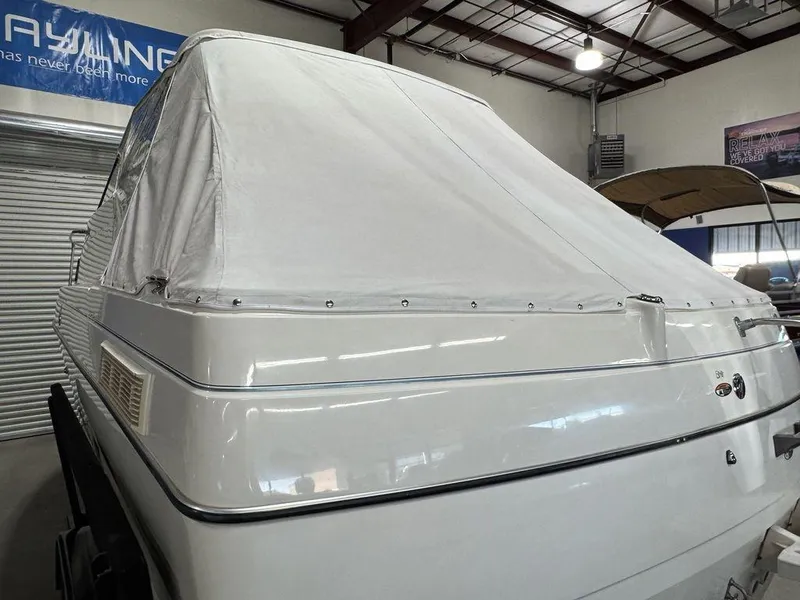 Slide: The Image of 2000 Bayliner 2252 Ciera Express boat with white cover in indoor storage. - 22